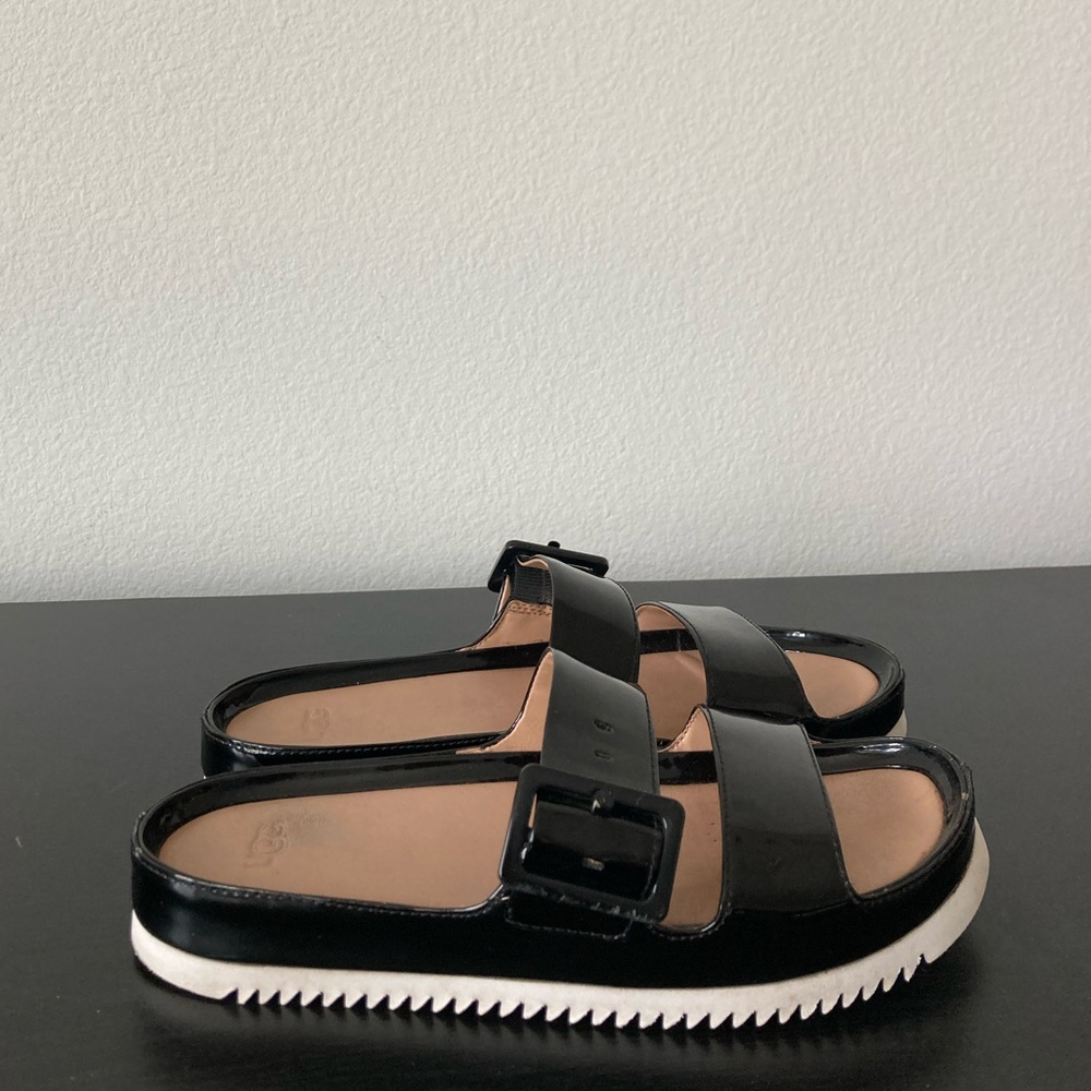 Black UGG sandals with adjustable buckle detailing